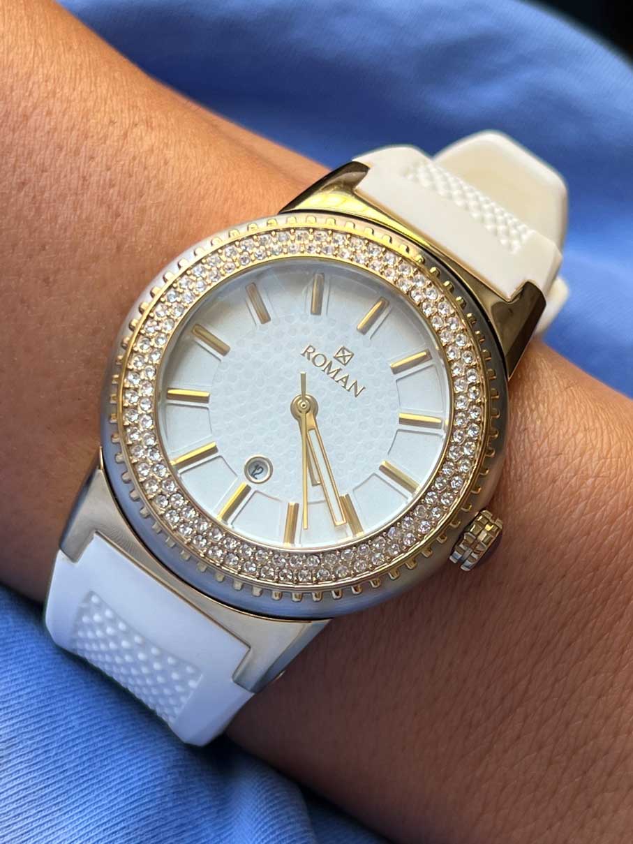 Roman yellow and white watch with white rubber strap.