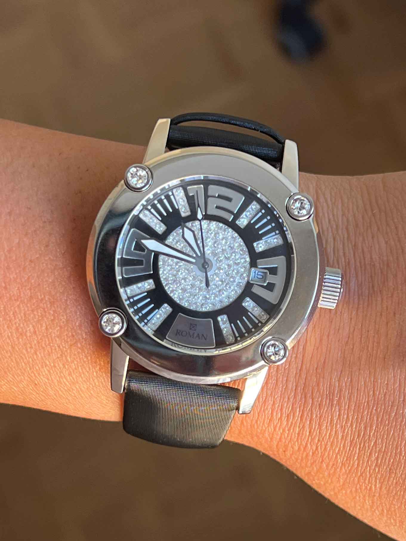 Reloj Román blanco y negro con correa de seda negra.