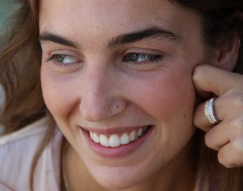 Elegante media alianza de plata chapada o rodiada y circonitas