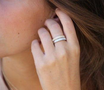 Elegante media alianza de plata chapada o rodiada y circonitas