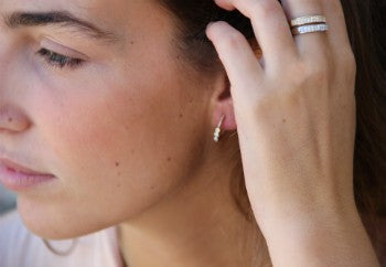 Elegante media alianza de plata chapada o rodiada y circonitas