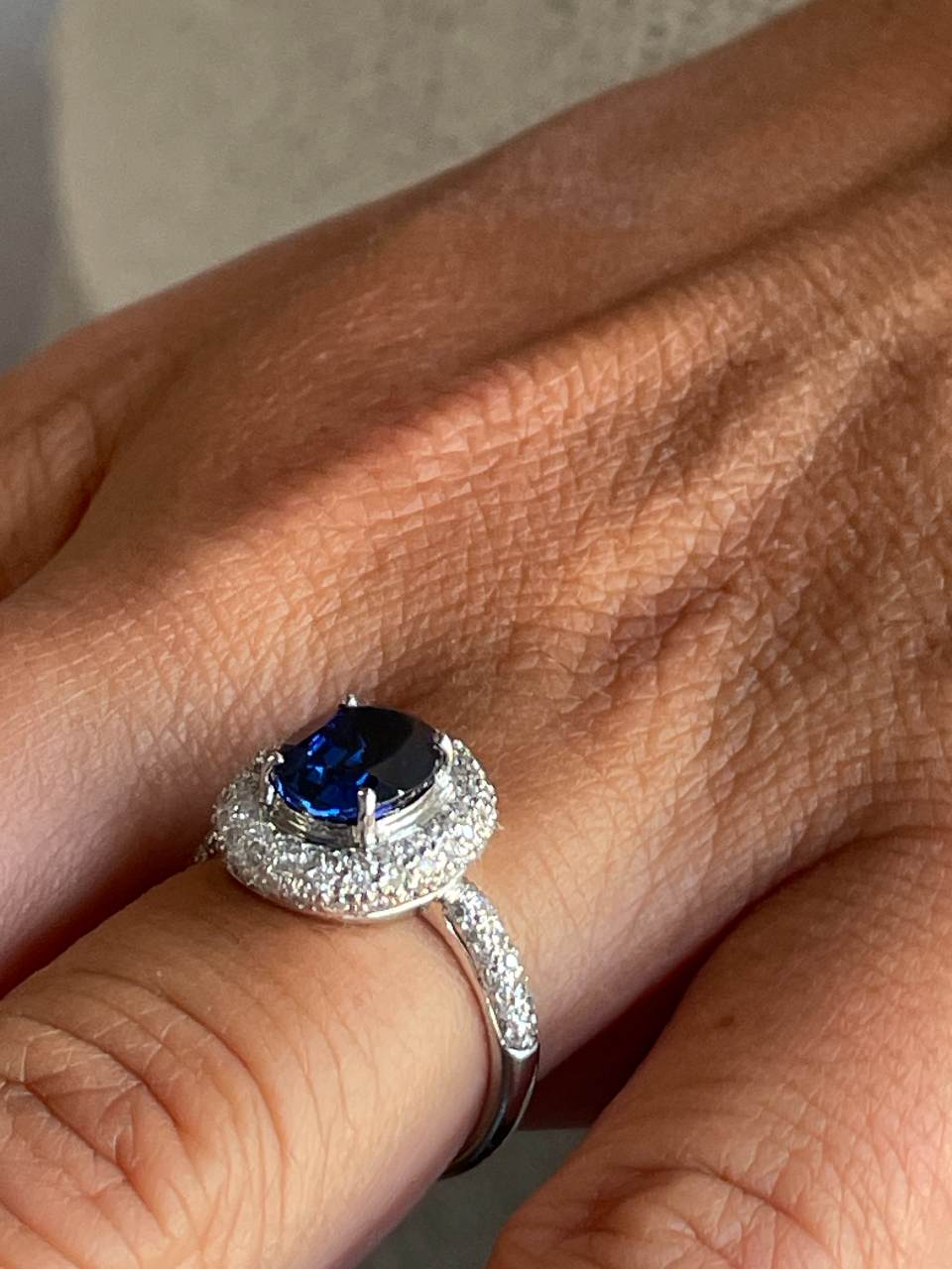 POIO ring with sapphire center and diamonds in 18k white gold.