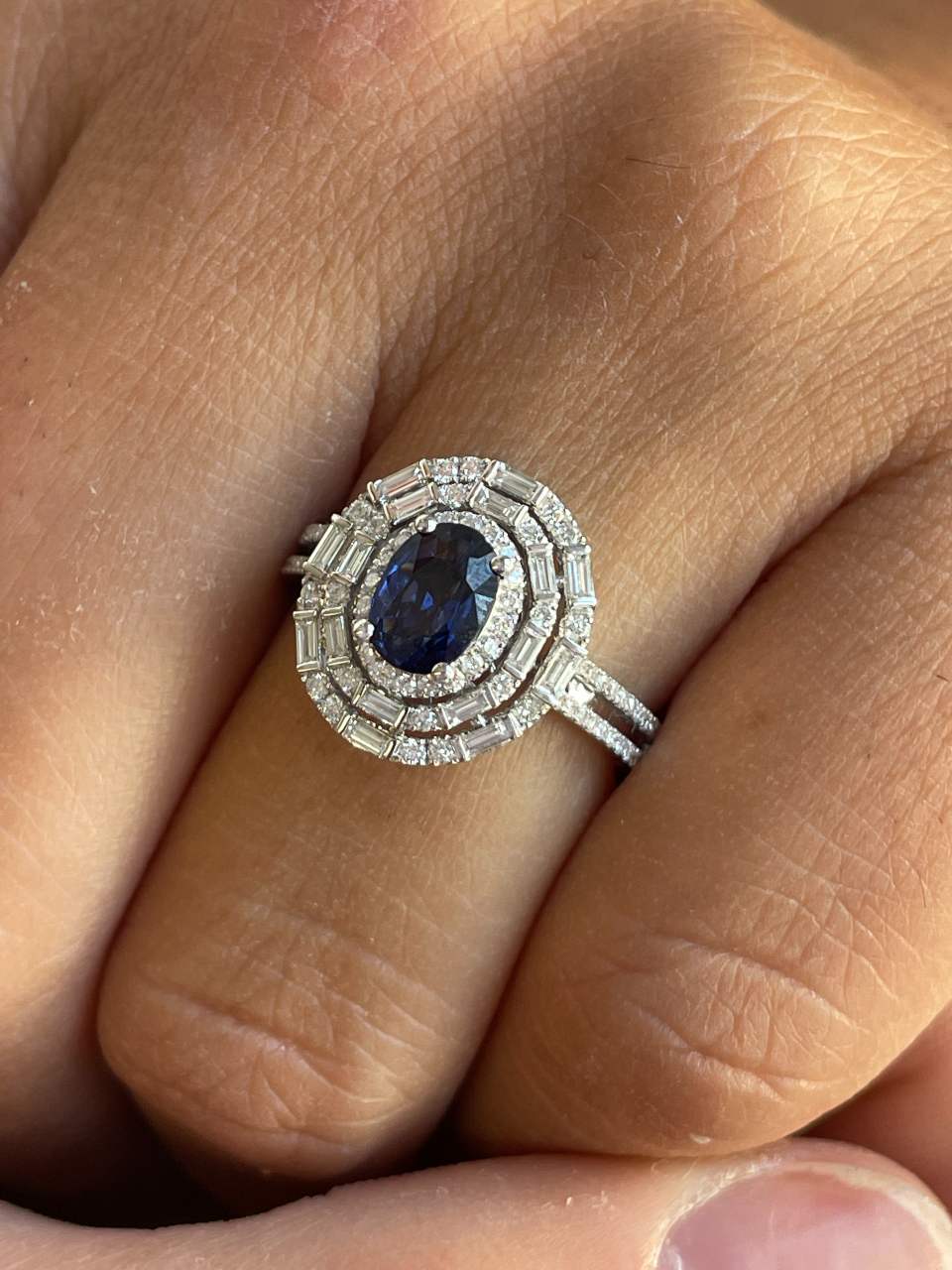POIO ring with sapphire center and diamonds in 18k white gold.