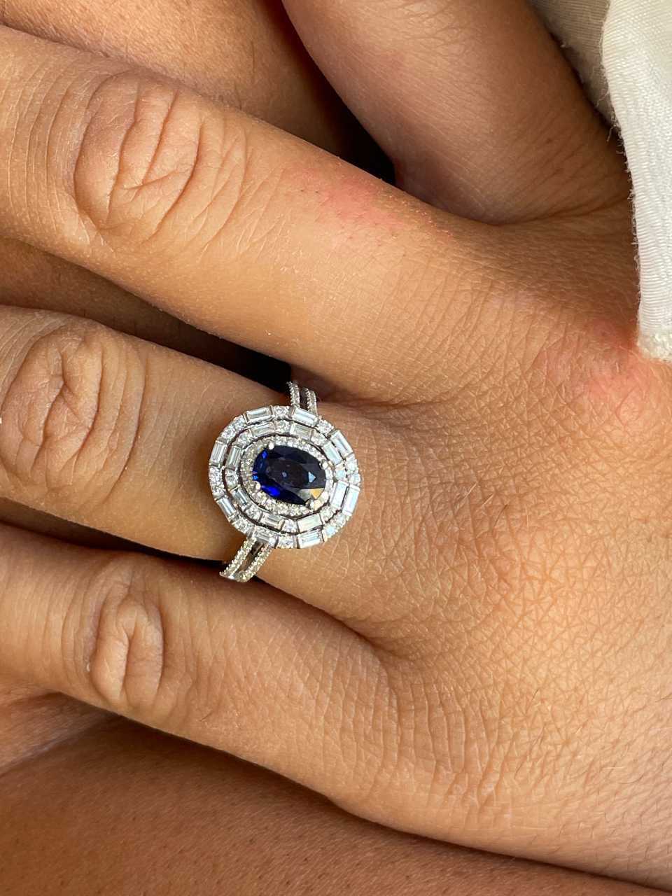 POIO ring with sapphire center and diamonds in 18k white gold.