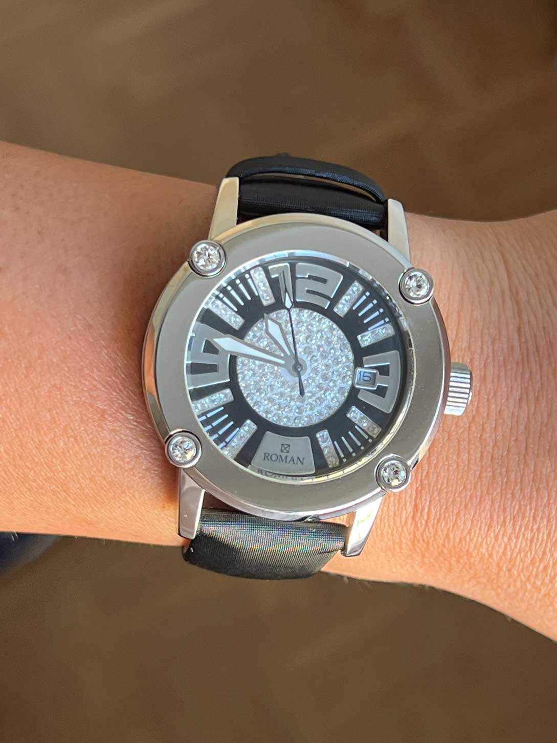 Reloj Román blanco y negro con correa de seda negra.