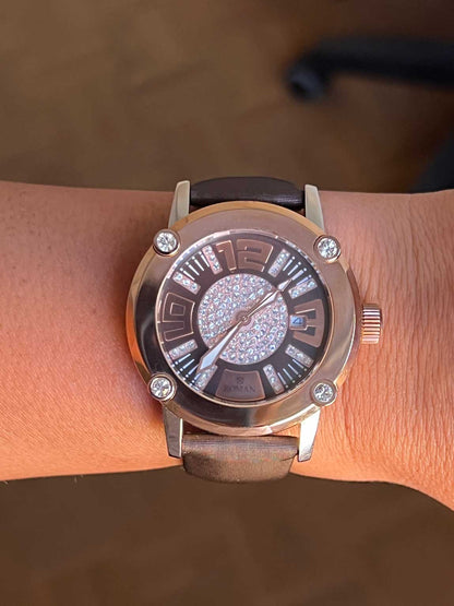 Reloj Román rosa y blanco con correa de seda color marrón.